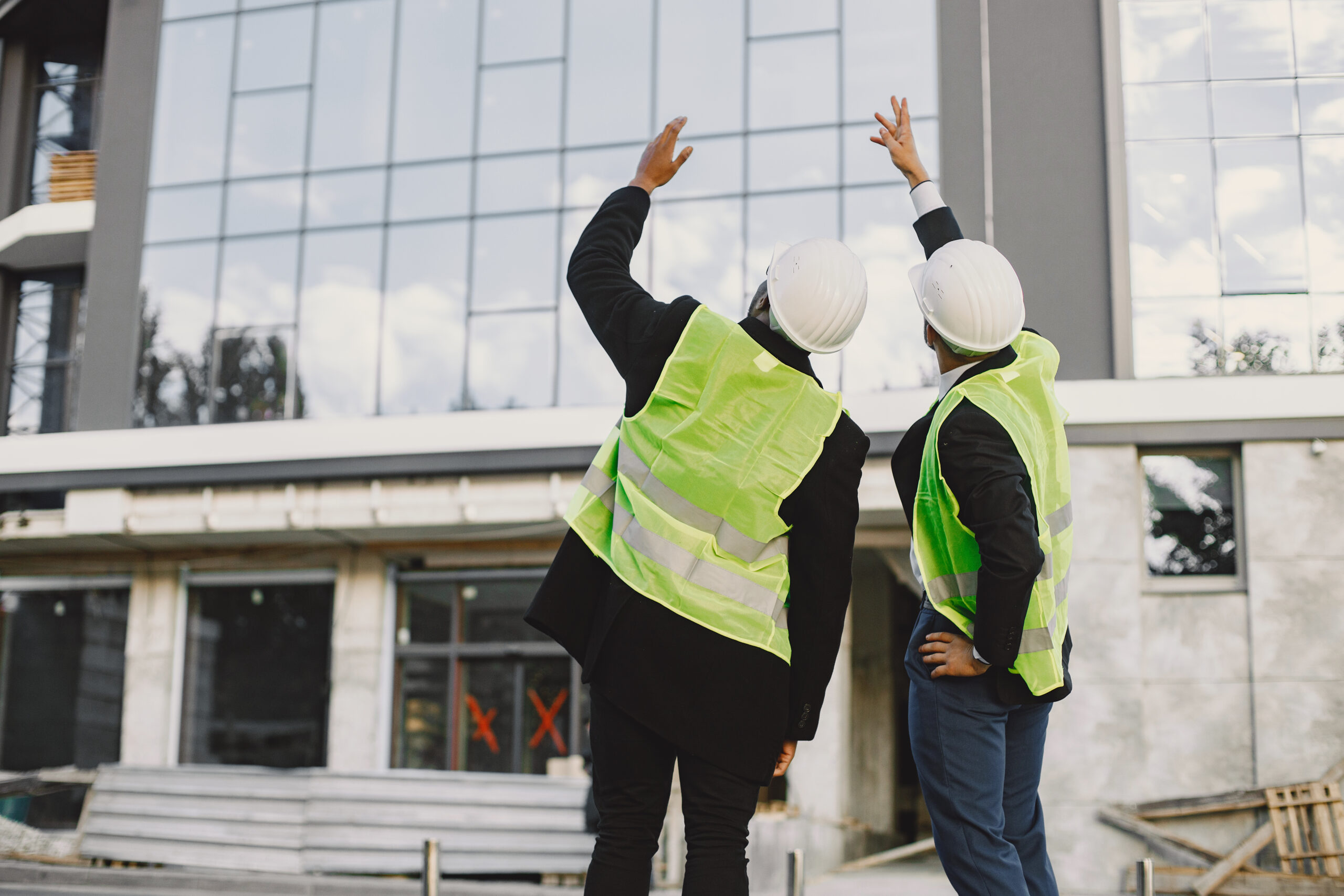 two ingeneers discusing building project at skyscraper